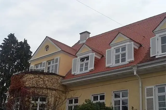 Das gleiche Gebäude nach der Sanierung: neues Dach, renovierte Fassaden