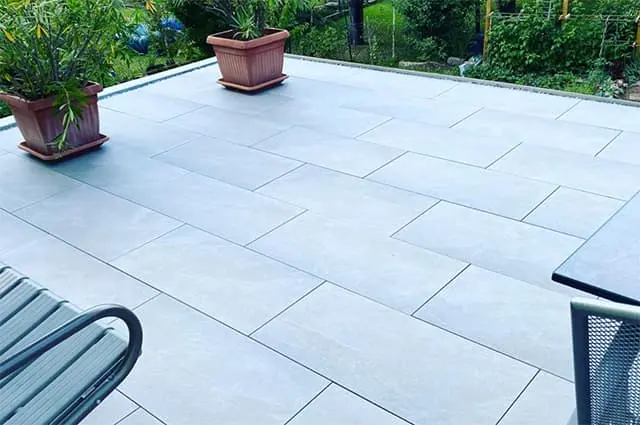 Gesamtansicht der modern sanierten Terrasse mit großen grauen Fliesen