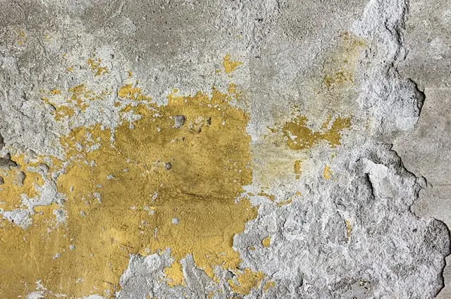 Abgeplatzter Beton an Wandfläche mit sichtbarem Sanierungsbedarf